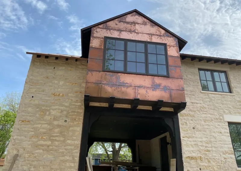 Copper metal panel facade on a stone building for Skylight Installation in Neenah